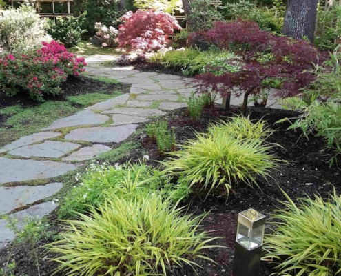 Lovely Zen garden with grasses, flowers, and flagstone walkways